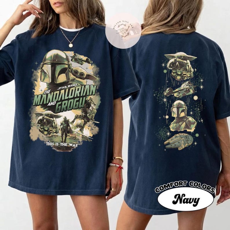 May include: Navy blue t-shirt with graphics from The Mandalorian and Grogu. The front design includes the text "The Mandalorian and Grogu" and "This is the Way". The back of the shirt has character and ship illustrations.