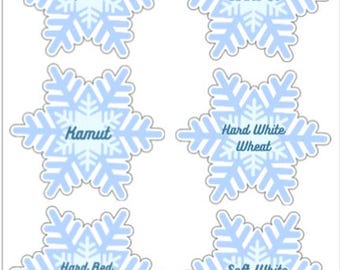 May include: Six light blue snowflake-shaped labels with white outlines. Each label features a different grain type: Spelt, Einkorn, Kamut, Hard White Wheat, Hard Red Wheat, and Soft White Wheat. The text is in a light blue font.