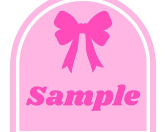 May include: A pink label with a white border and a pink bow at the top. The word "Sample" is written in pink, stylized font below the bow. The background is a lighter shade of pink.