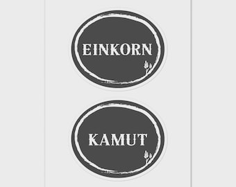 May include: Two dark gray circular stickers with white text. The top sticker reads "EINKORN" and the bottom sticker reads "KAMUT". Each sticker has a white, textured border and a small wheat sprig graphic.