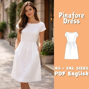 May include: A white pinafore dress with short sleeves and pockets. The dress is knee-length and has a fitted bodice. The image also includes a line drawing of the dress and text that reads "Pinafore Dress" and "XS - 5XL SIZES PDF English".