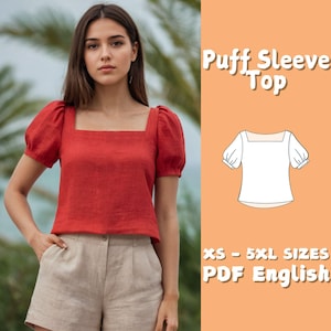 Pode incluir: Uma blusa vermelha com mangas bufantes e decote quadrado. A blusa é combinada com shorts bege. A imagem também inclui um desenho linear da blusa e o texto "Puff Sleeve Top" e "XS - 5XL SIZES PDF English".