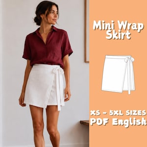 Può includere: Una minigonna a portafoglio bianca con chiusura a fiocco laterale, abbinata a una camicia bordeaux abbottonata. L'immagine include il testo Mini Wrap Skirt, XS - 5XL SIZES, PDF English e un disegno al tratto in bianco e nero del modello.
