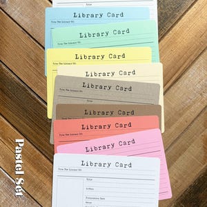 May include: A set of ten rectangular library cards in various pastel colors including white, blue, green, yellow, cream, brown, peach, and pink. Each card features the text Library Card, From The Library Of, and lines for book details.