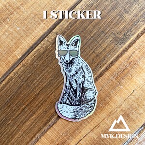 May include: A holographic sticker featuring a black and white illustration of a fox wearing sunglasses. The sticker has a rainbow iridescent finish.