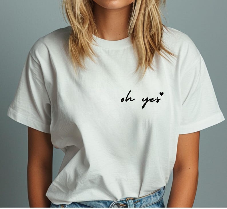 Puede incluir: Camiseta blanca con el texto "oh yes" y un peque&ntilde;o coraz&oacute;n.