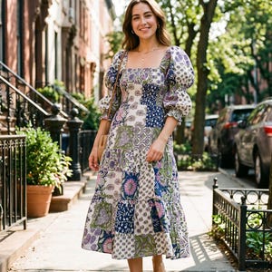 May include: A midi-length dress featuring a patchwork pattern of floral and geometric prints in shades of blue, green, pink, and white. The dress has a square neckline, voluminous puff sleeves with elasticated cuffs, and a tiered skirt.