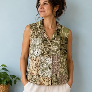 Puede incluir: Una camisa sin mangas con botones que presenta un diseño de patchwork con varios patrones florales y botánicos en tonos verde oliva, salvia, beige y marrón. La camisa tiene un cuello clásico y un dobladillo recto, confeccionada con paneles de tela.