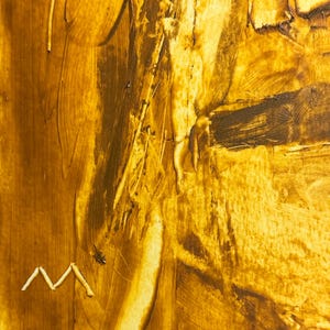 May include: Abstract art piece with a textured surface, featuring shades of gold and brown. The artwork has visible brushstrokes and a small, white, zig-zag shape near the bottom. The overall effect is a warm, earthy aesthetic.