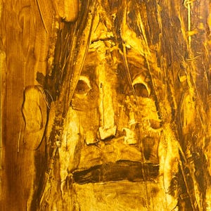 May include: Abstract oil painting on canvas, featuring a face with a prominent nose and dark, expressive eyes. The artwork uses a palette of warm, earthy tones, primarily shades of yellow and brown, with visible brushstrokes creating texture.