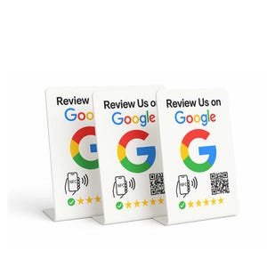 May include: Three white, angled display cards with the Google logo and the words "Review Us on Google." Each card features a QR code, NFC symbol, and star rating. The Google logo is in red, yellow, green, and blue.