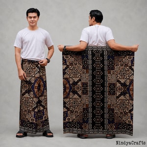 May include: A white t-shirt and a sarong featuring a dark brown, black, and blue batik pattern with intricate floral and geometric motifs. The sarong is displayed both wrapped around the waist and held open to show the full rectangular fabric design.