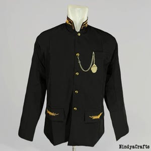 May include: Black jacket with gold embroidered accents on the collar, pockets, and cuffs. The jacket features gold buttons and a decorative chain with a medallion. The jacket is displayed on a mannequin.