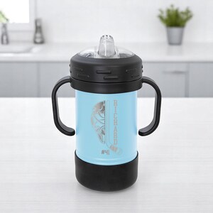 May include: A light blue sippy cup with a black lid, handles, and base. The cup features a hockey-themed design with the name "RICHARD" and the number "#41" etched on the side. The cup has a clear, flip-top spout.