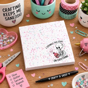 May include: A square notepad with a white background featuring pink, blue, and purple speckles. The notepad displays a cartoon skeleton holding a bottle with the text, I SPRINKLE THIS STUFF ON EVERYTHING, printed in black around the illustration.