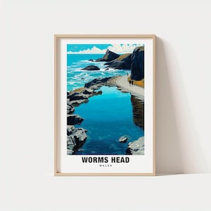 May include: A framed art print featuring a coastal landscape with a turquoise pool of water in the foreground. The image includes a pathway, cliffs, and the text "WORMS HEAD WALES" at the bottom. The sky is blue with white clouds.
