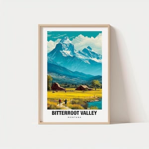 Puede incluir: Una impresión enmarcada que presenta un paisaje del valle de Bitterroot en Montana. La obra de arte representa una cordillera con picos nevados, un campo amarillo, un río y dos personas caminando. El texto "BITTERROOT VALLEY MONTANA" está en la parte inferior.