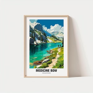 May include: A framed art print featuring a vibrant landscape of Medicine Bow Mountains. The artwork depicts a turquoise lake surrounded by green grass, rocky shores, and snow-capped mountains under a blue sky. Two figures walk along a path. The text "MEDICINE BOW MOUNTAINS" is at the bottom.