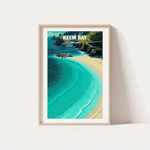 May include: A framed print of Keem Bay, Ireland, featuring a turquoise ocean and a sandy beach. The artwork showcases a winding road along a green cliffside, with the text "Keem Bay Ireland" at the top. The print is in a light-colored wooden frame.