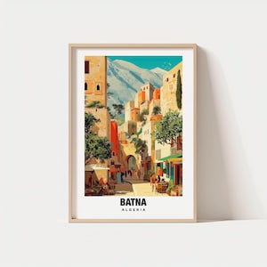 May include: A framed art print depicting a street scene in Batna, Algeria. The image showcases colorful buildings, trees, and a mountain range. The text "BATNA ALGERIA" is displayed at the bottom of the print, set against a white background.