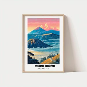 Könnte beinhalten: Ein gerahmter Kunstdruck mit einer farbenfrohen Landschaft des Mount Bromo in Indonesien. Das Kunstwerk zeigt Vulkane, Wolken und einen lebendigen Himmel mit dem Text "MOUNT BROMO INDONESIA" am unteren Rand. Die Farbpalette umfasst Blau-, Orange- und Rosatöne.