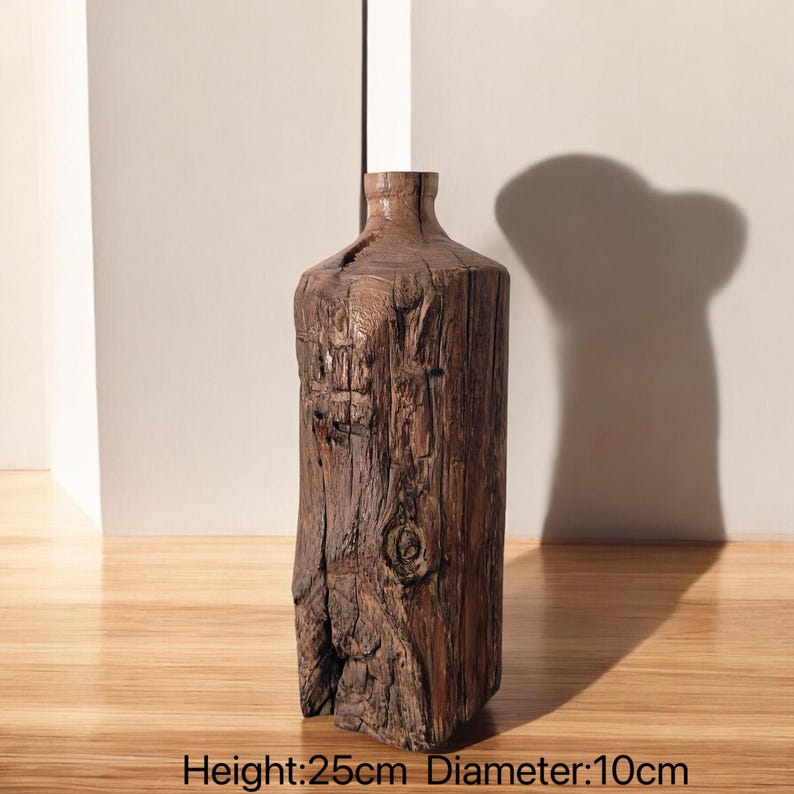 May include: A rustic wooden vase with a natural, weathered finish. It has a cylindrical shape with a slightly flared opening. The vase measures 25 cm in height and 10 cm in diameter.