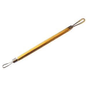 May include: A yellow and silver comedone extractor tool. The tool has a textured, ridged handle and a loop on each end. One loop is a small circle, and the other is a larger oval.