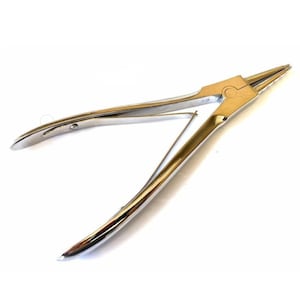 May include: A pair of silver-colored pliers with long, curved handles and pointed tips. The pliers have a pivot point in the center and a spring mechanism to keep them open. The tool is designed for precision work.