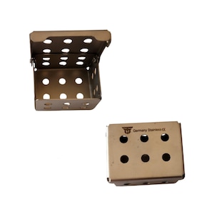 May include: Two stainless steel sterilization boxes with perforated sides and lids. One box is shown open, revealing the interior, while the other is closed, displaying the text Germany Stainless CE and a logo on the top surface of the metal container.