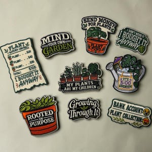 May include: A collection of nine embroidered patches featuring plant-themed designs and text. Phrases include "Plant Garden Center I Bought It Anyway," "Mind Your Own Garden," "Send Money For Plants," "My Plants Are My Children," and "Rooted In Purpose."