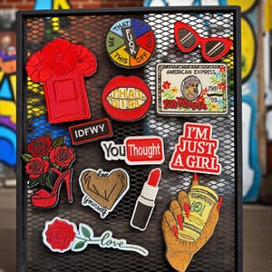May include: A collection of embroidered patches on a black mesh background. Patches include a red high-heeled shoe, a lipstick, a coffee cup, and text patches that say "I'M JUST A GIRL" and "YOU THOUGHT".