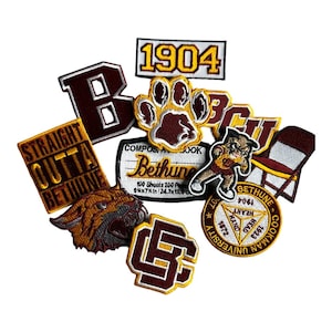 May include: A collection of embroidered patches in maroon, gold, and white. The patches feature text, a paw print, a tiger head, and the text "STRAIGHT OUTTA BETHUNE". Other patches include "1904", "Bethune", and "Cookman University".