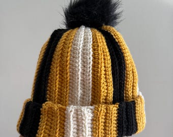 Gorro de rayas negras y doradas tejido a mano con pompón de piel sintética
