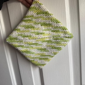 May include: A green and white crocheted pot holder with a loop for hanging.