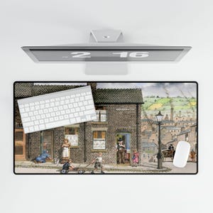 May include: A rectangular mouse pad featuring a detailed illustration of a street scene with a brick building, people, and a horse-drawn carriage. A white keyboard and mouse are on the pad. The monitor above displays the numbers "2 16".