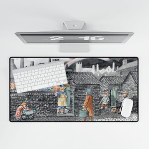 May include: A rectangular mouse pad featuring a black and white illustration of a village scene with children. A white keyboard and mouse are on the pad. A computer monitor is above the pad.