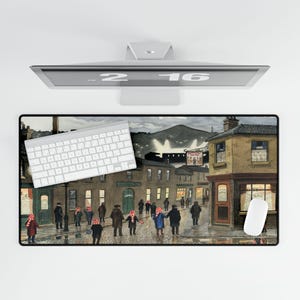 May include: A rectangular mouse pad featuring a street scene with people wearing red and white striped scarves. A white keyboard and mouse are on the pad. A computer monitor is above the pad.
