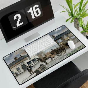 May include: A rectangular mouse pad featuring a watercolor painting of a horse-drawn cart in front of a pub. The scene is set on a cobblestone street with buildings and figures. A white keyboard and mouse are on the pad.