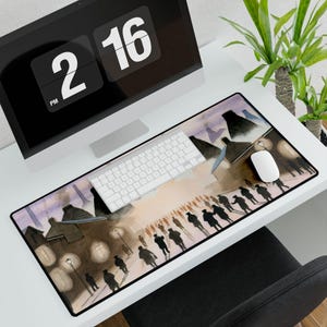 May include: A rectangular desk mat featuring a watercolor painting of a street scene with silhouetted figures and buildings. The mat is black-edged and sits on a white desk, with a white keyboard and mouse.