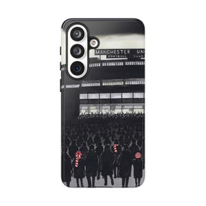 May include: A black phone case with a monochrome illustration of a football stadium. The text "MANCHESTER UNITED FOOTBALL CLUB" is visible. The image includes a crowd of people and candy canes.