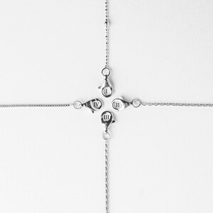 May include: Four silver chains with clasps, each labeled with Roman numerals I, II, III, and IV.