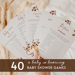 May include: A set of printed baby shower game cards featuring a coffee theme with illustrations of coffee beans and cups. The cards include titles like Baby Animal Match, Pass the Baby, and The Price is Right, with lists of questions and lines for writing.
