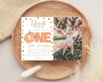 May include: A thank you card featuring a baby photo and the text "Thank You for Celebrating Our One Little Pumpkin." The card has an orange and brown pumpkin and leaf design. The baby is wearing a white outfit and a headband.