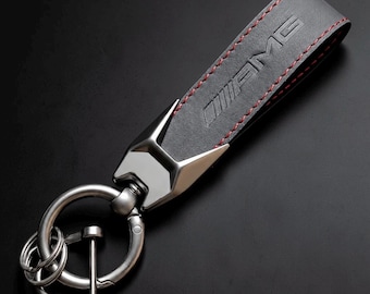 Mercedes Benz AMG key fob in black with red stitching, made of leather and featuring the AMG logo.