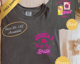 Może przedstawiać: Ciemnoszary t-shirt z różowym napisem z przodu o treści Jessica's Bach & Boozy Bride. Z tyłu koszulki znajduje się grafika przedstawiająca flaminga, kwiat hibiskusa oraz napis Bach & Boozy Bride Miami, FL.