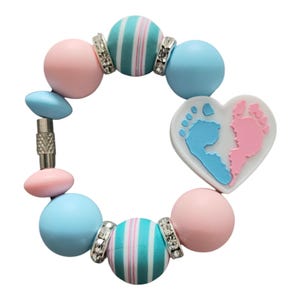 May include: A bracelet with pink, blue, and turquoise beads, a heart charm with blue and pink footprints, and silver accents.