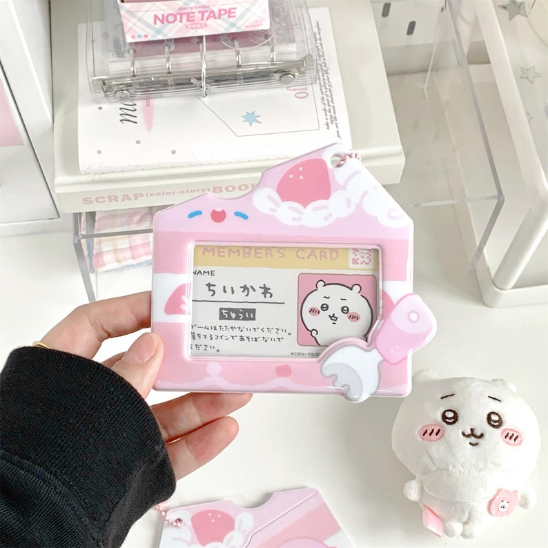 May include: A pink and white member's card holder with a cartoon bear illustration. The holder has a house-shaped design with a strawberry and cloud motif. The text "MEMBER'S CARD" is visible, along with Japanese text.