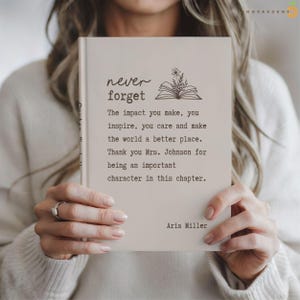 May include: A light beige book with dark brown text that reads: never forget, The impact you make, you inspire, you care and make the world a better place. Thank you Mrs. Johnson for being an important character in this chapter. Aria Miller.