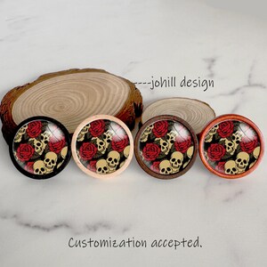 May include: Four round decorative objects with a skull and rose design. The objects have a black, light wood, dark wood, and orange frame. The design includes red roses and tan skulls. The text "---johill design" and "Customization accepted" are visible.