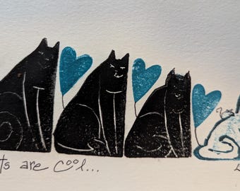 May include: A black and white linocut print of five cats with blue hearts. The print reads "Cats are cool..." at the bottom.